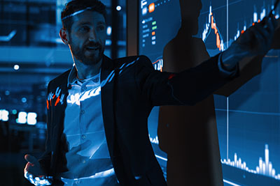 Man presenting market performance on with screen projector.