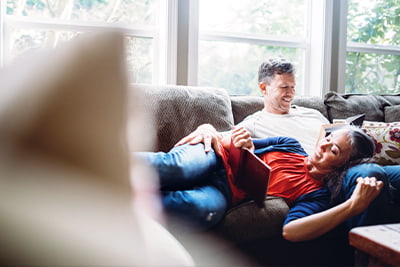 Investing, couple on couch reading books