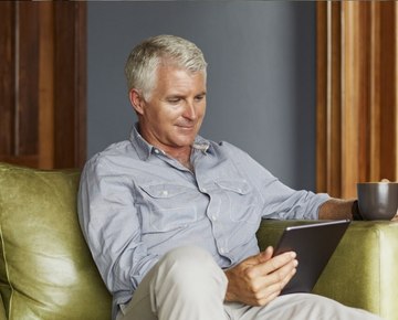Contact us general queries, man sitting on couch looking at a tablet