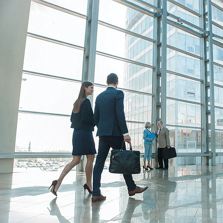 business people walking a talking in a big office building