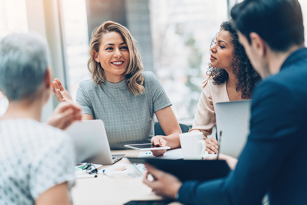 Group of business individuals having a conversation using desktops