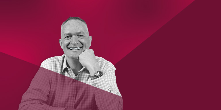 Red banner with man smiling in centre and text 