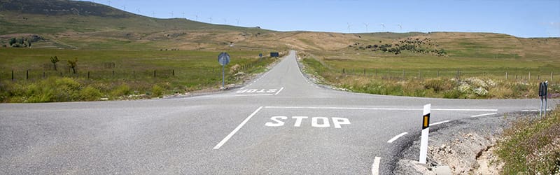 Intersection of a roads crossing surrounded by green fields