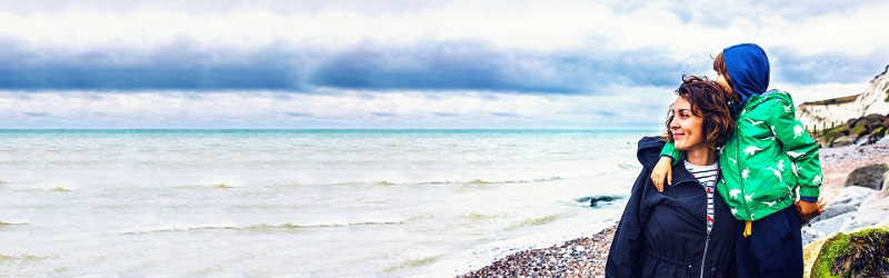 Financial planning image of a woman and son on a beach