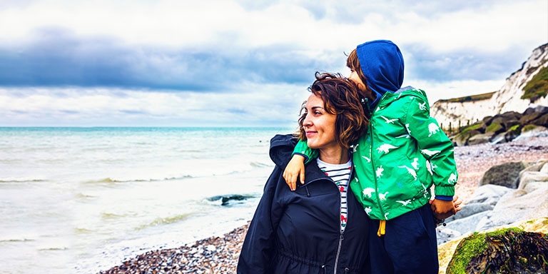 Financial planning image of a woman and son on a beach