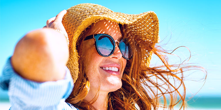 Living well image of a smiling woman in a sun hat