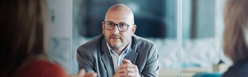 Budget 2027 aimed to support business owners, man listening in a meeting
