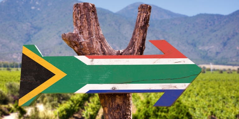 South African wooden arrow with flag nailed on branch