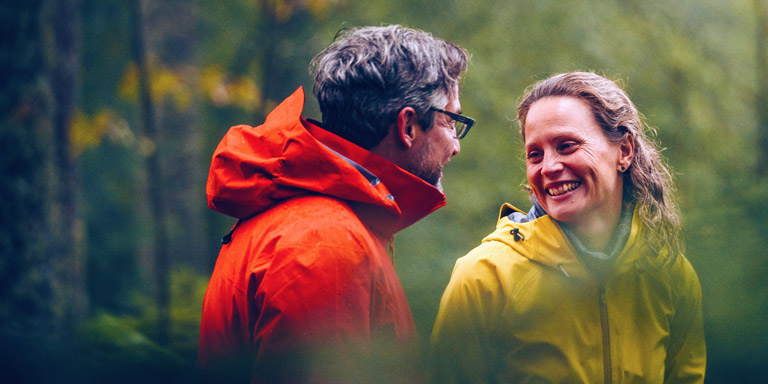 How to invest at Davy image of couple smiling at each other in forest