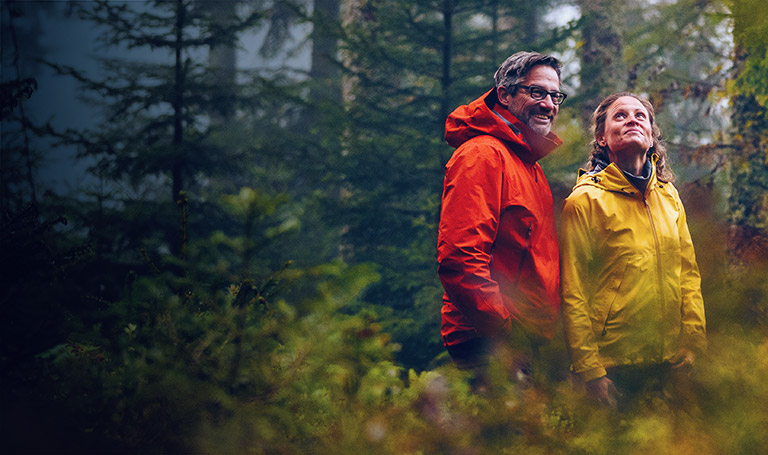 Why invest now when the market is high image of a happy couple walking in a forest