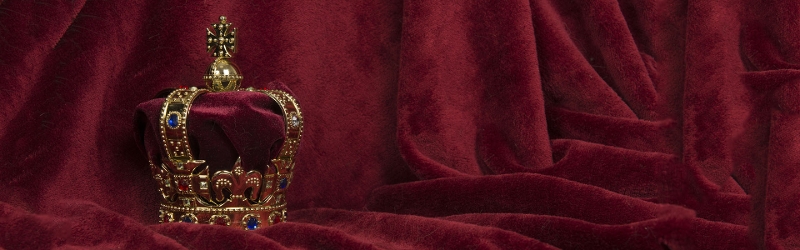 Image of a crown against a red velvet background