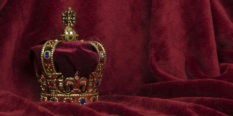 Image of a crown against a red velvet background
