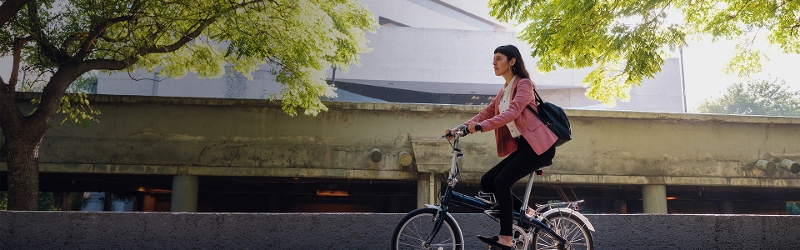 Woman riding a bike with trees in the background