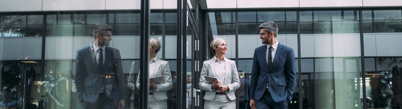 Two professionals working by office building