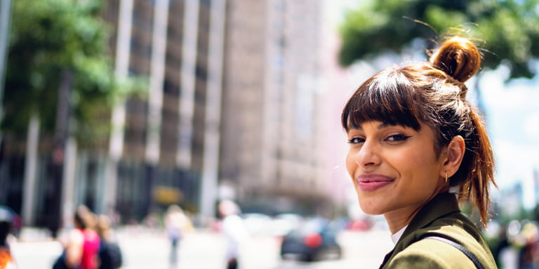 Customer services image of smiling person on a busy street